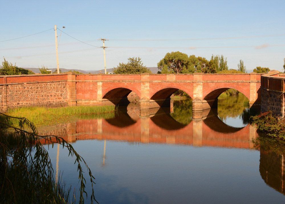 A Bridge Over a Body of Water with Trees in The Background — Glass in Campbelltown, NSW