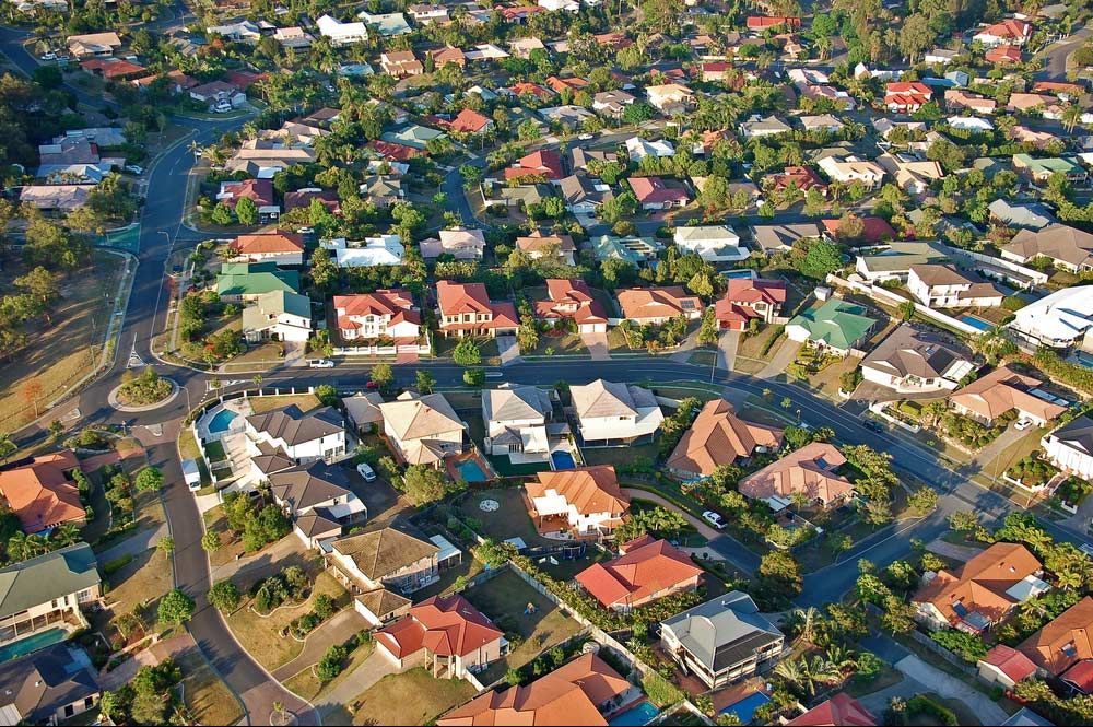 An Aerial View of A Residential Area with Lots of Houses and Trees — Glass in Dapto, NSW