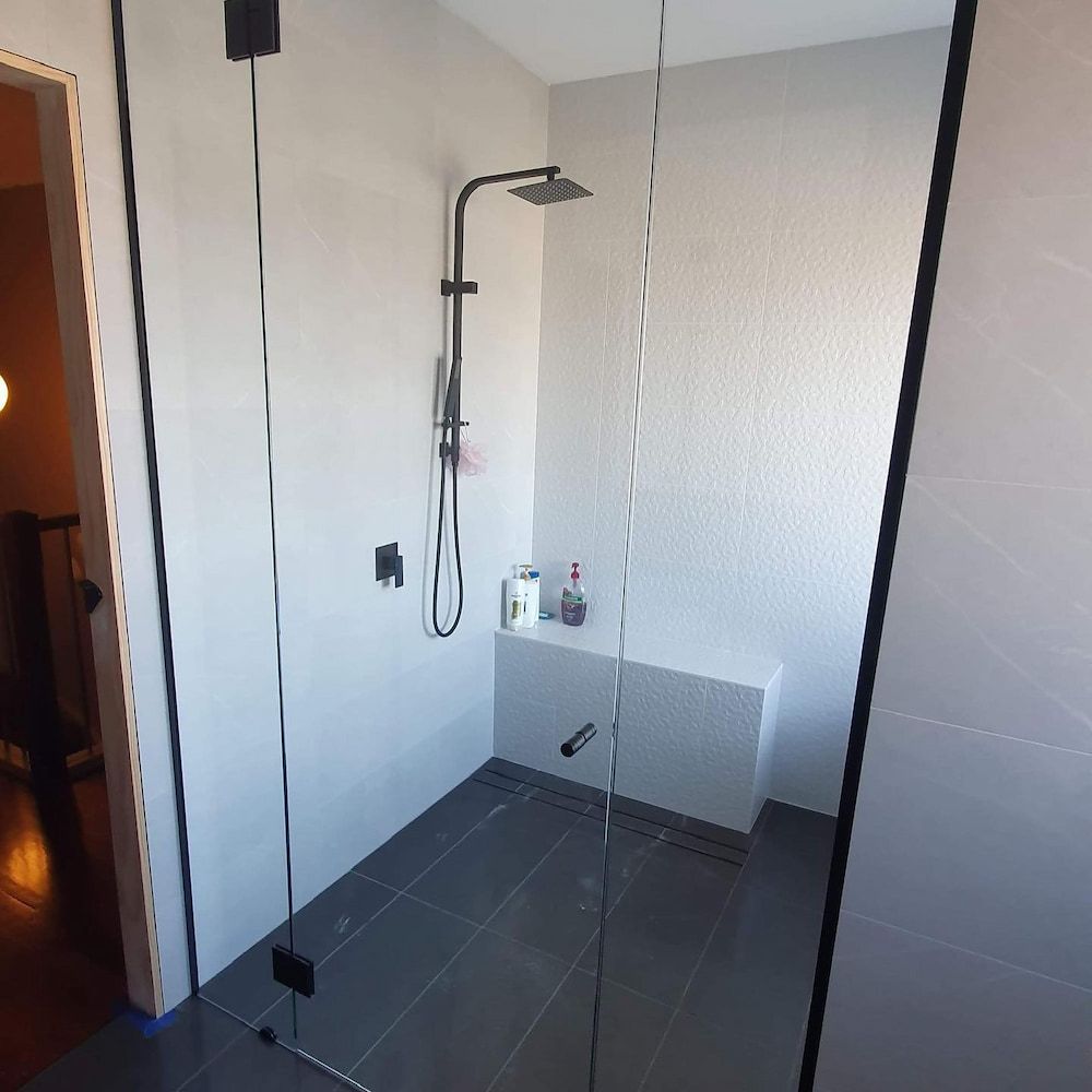 A Shower With a Glass Door and a Shower Head — Langson Glass in Wollongong, NSW 