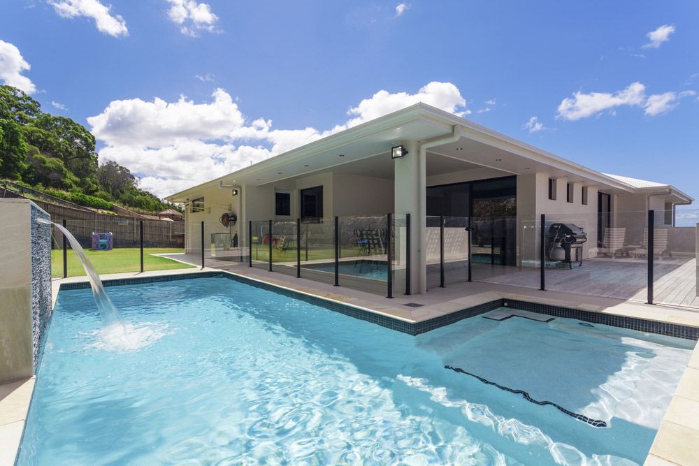 House with a Large Swimming Pool in Front of it — Glass in Bulli, NSW