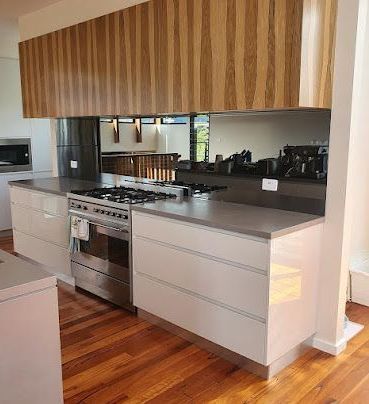 Modern Kitchen With Reflective Glass Splashback — Glass in Wollongong, NSW