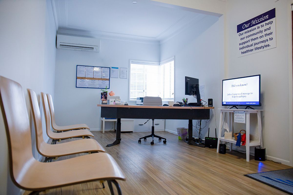 A Waiting Room With Chairs , A Desk , And A Television – Chermside, QLD - Hands From Heaven Remedial Therapy Clinic