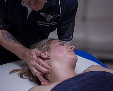 A Man Is Giving A Woman A Massage On A Table – Chermside, QLD - Hands From Heaven Remedial Therapy Clinic