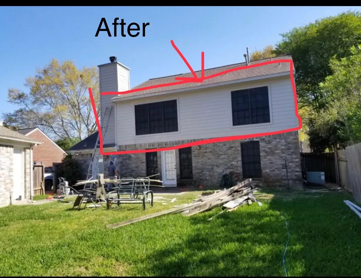 Backyard view of a two-story house with stone and siding, under construction.