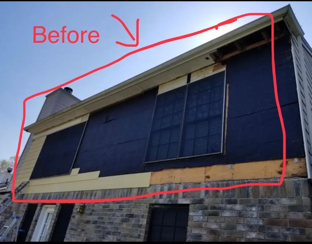 Exterior of a house under construction. Black covering and exposed wood on the wall. Marked as 