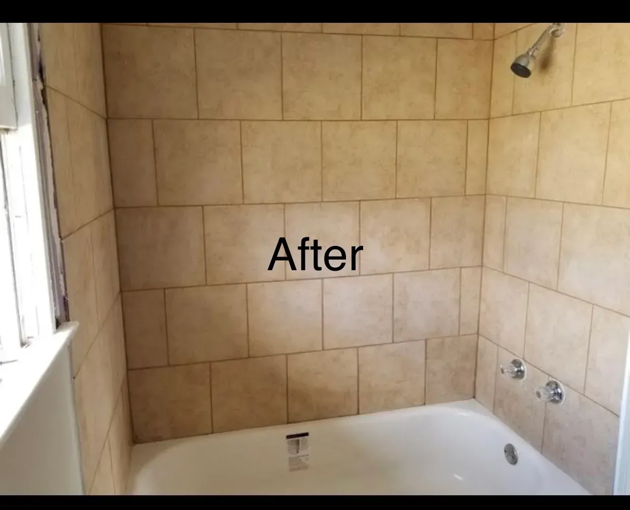 Bathroom with beige tiled walls, white tub, and silver fixtures; 