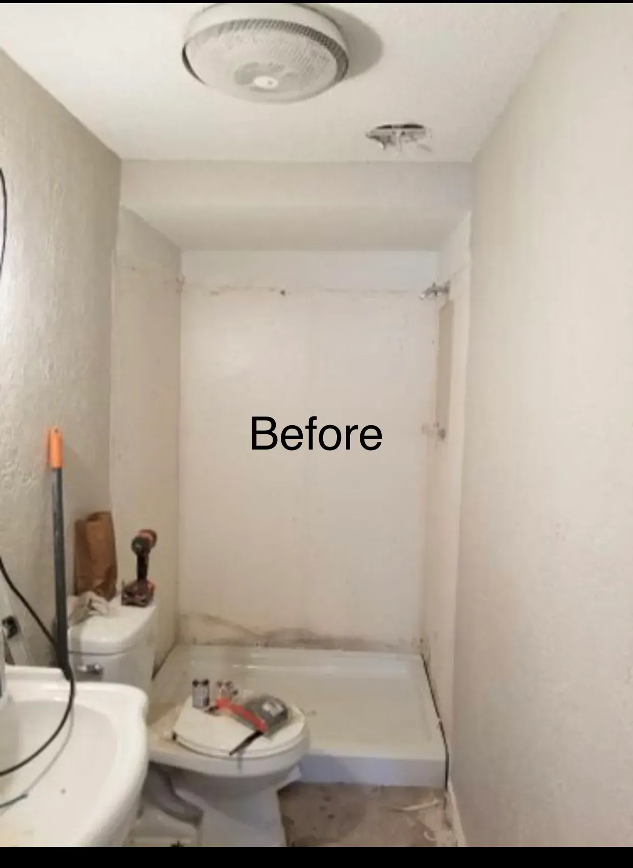 Small, dingy bathroom with a white toilet, shower, and sink. The walls are painted with beige/grey.
