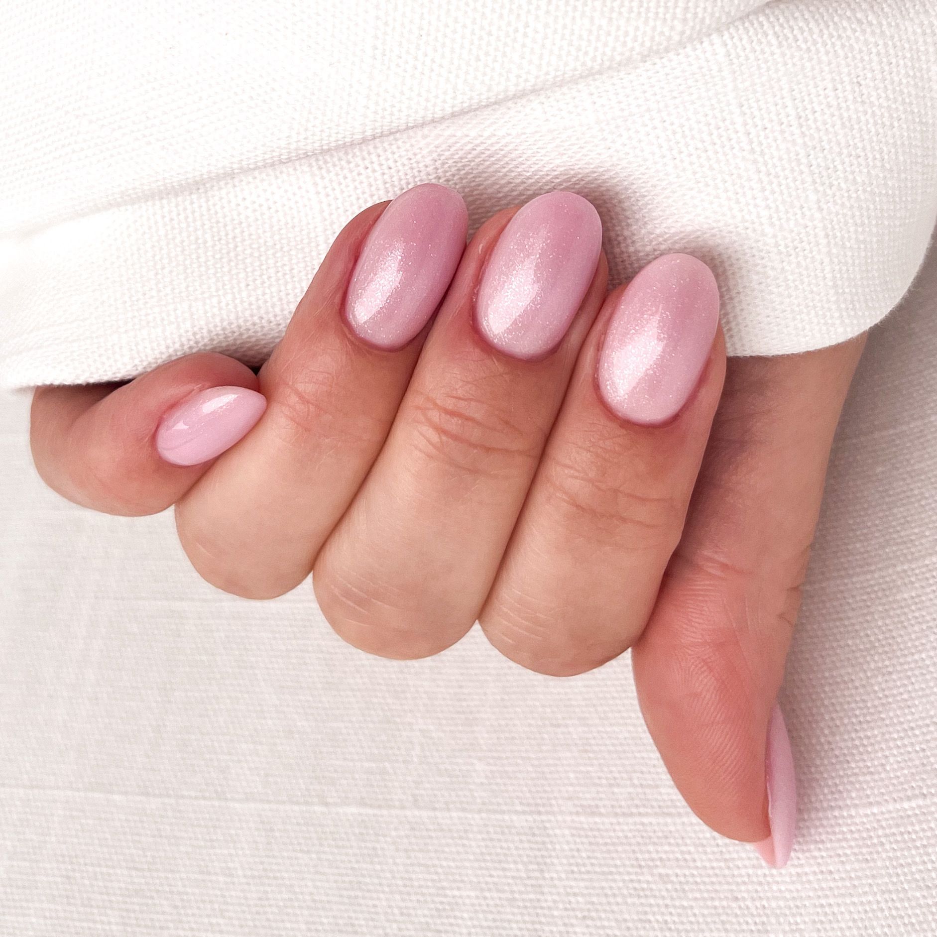 BIAB nagels gemaakt door de nagelstyliste in licht roze kleur met glitters.