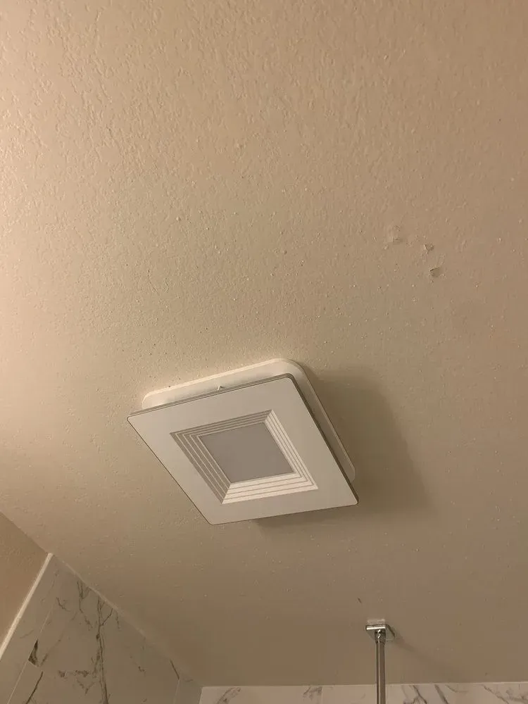 White ceiling with a square recessed light fixture and water spots.