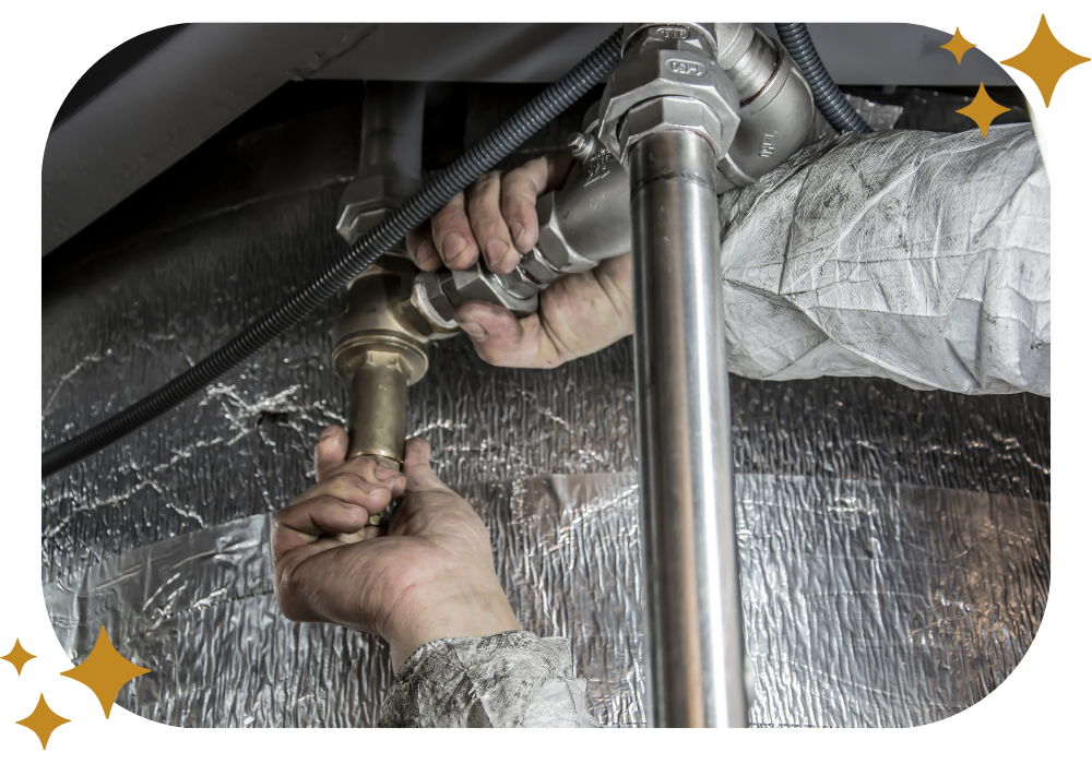 A plumber is fixing a pipe under a sink.