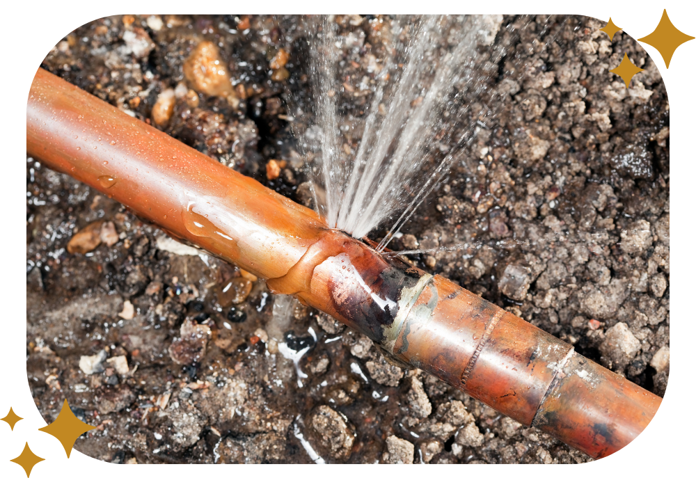 A copper pipe is leaking water on the ground.