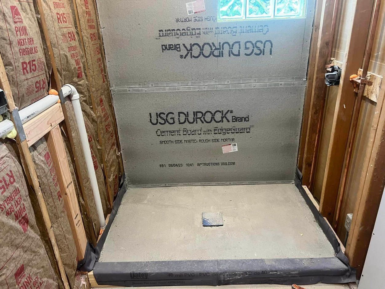 A shower stall is being built in a bathroom.