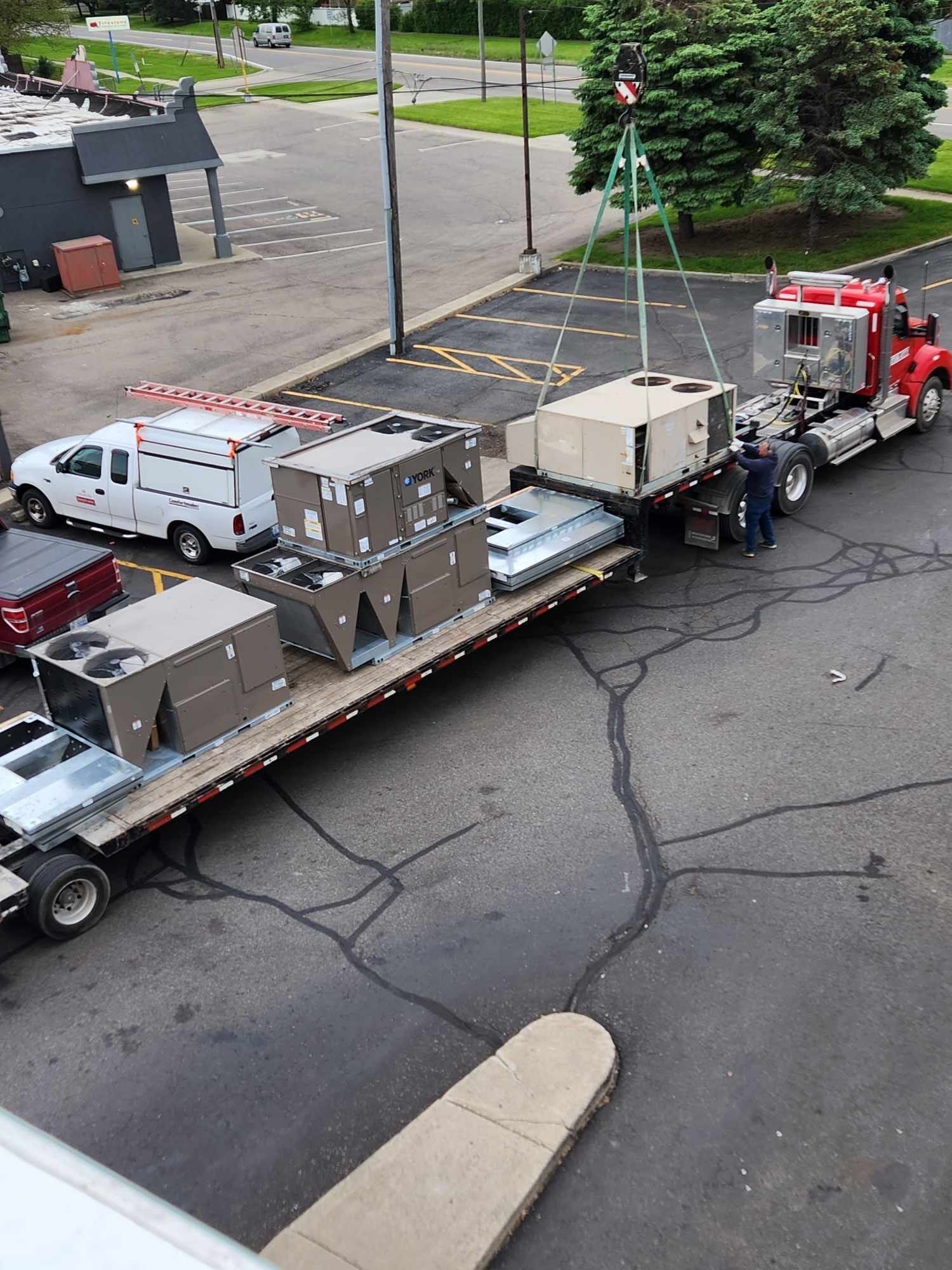 A red semi truck is carrying boxes on a flatbed