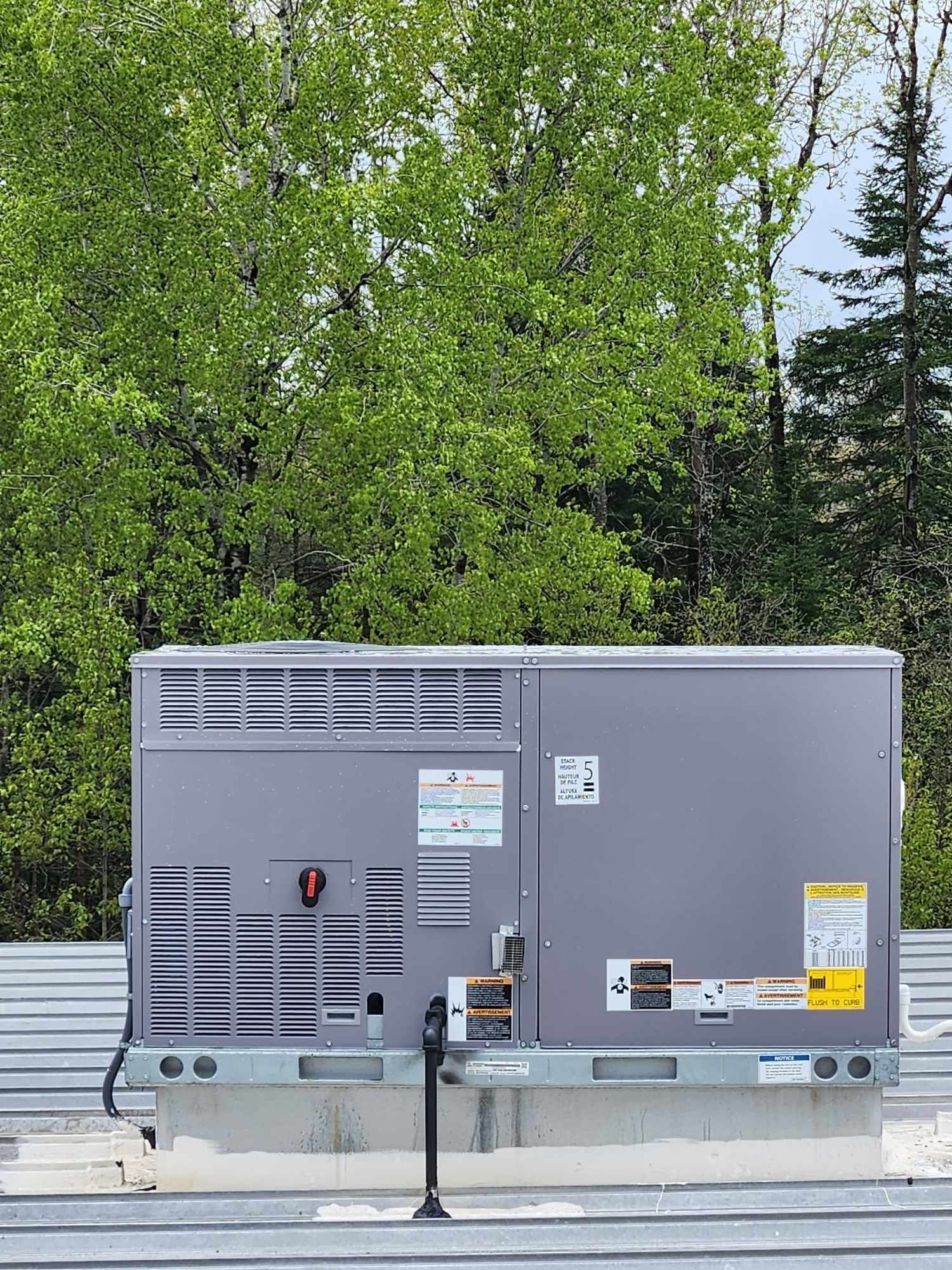 An air conditioner is sitting on top of a metal roof.