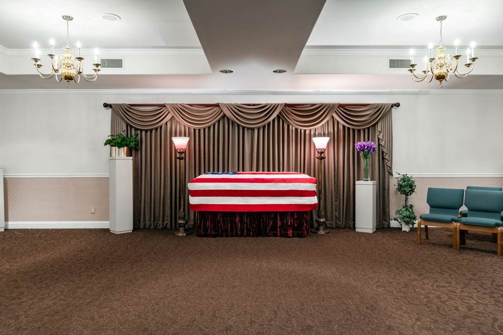 American flag-draped casket in a funeral hall.