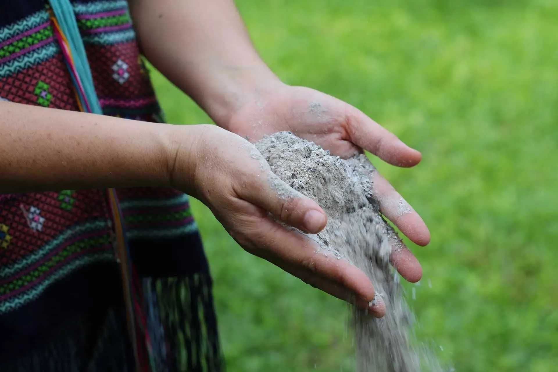 Ash Scattering Hands gently releasing ashes into the wind over a scenic outdoor landscape in Austin, TX
