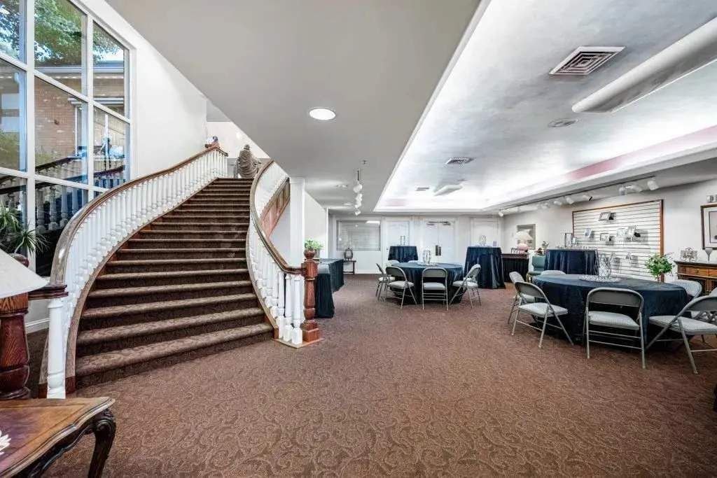 Committal Services Funeral home interior with curved staircase and reception area set for memorial in Austin, TX