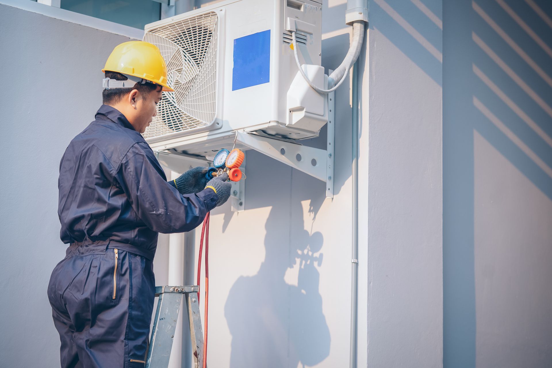 A commercial air conditioning contractor is fixing an air conditioner on a commercial building.
