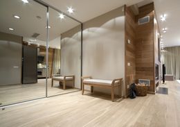 A hallway with a bench and a large mirror on the wall