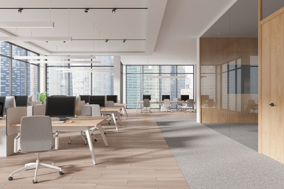 An empty office with a lot of windows and tables and chairs.