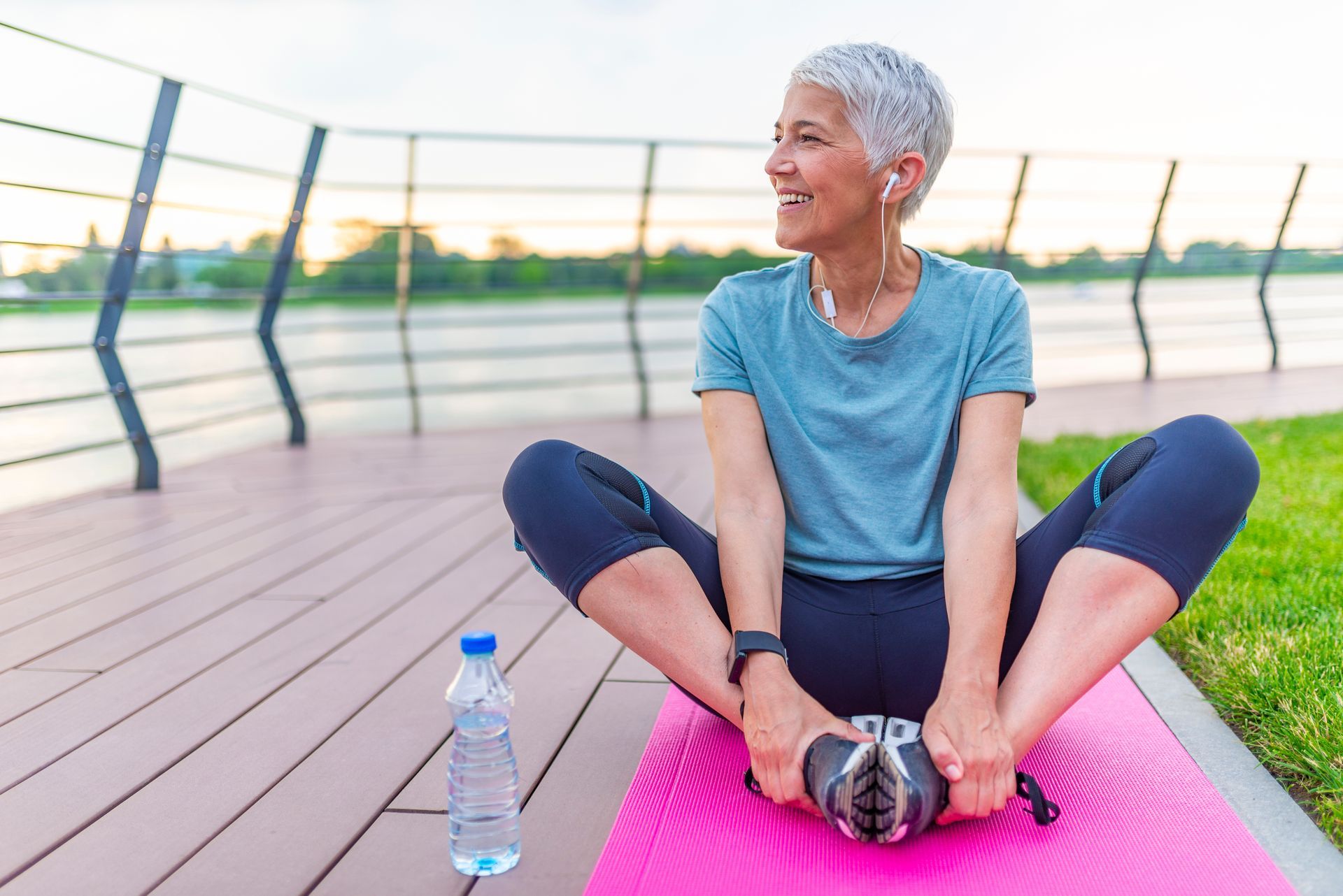 Older Lady with Short White Hair is Stretching while Listening To Music— Kym Connolly Wellness Coach in Svensson Heights, QLD