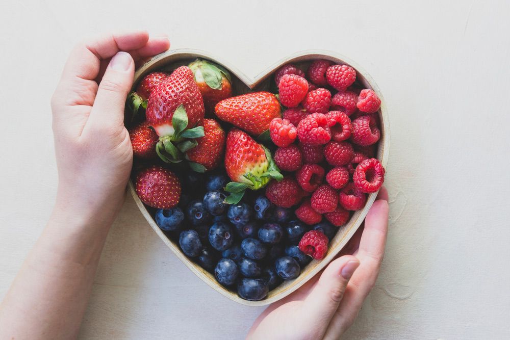 Holding A Heart Shaped Bowl Of Berries — Kym Connolly Wellness Coach in Svensson Heights, QLD