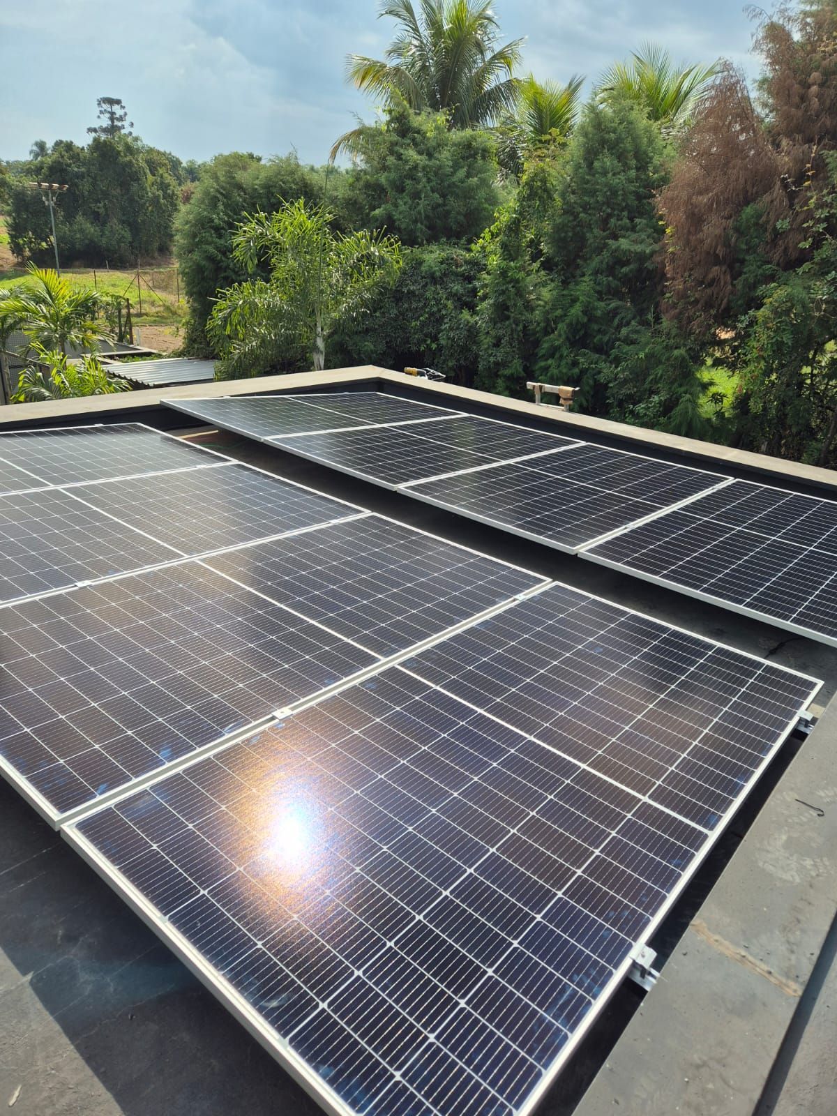 Uma fileira de painéis solares está no topo de um telhado.
