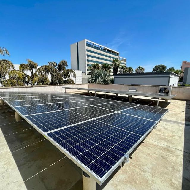 Uma fileira de painéis solares no telhado de um edifício