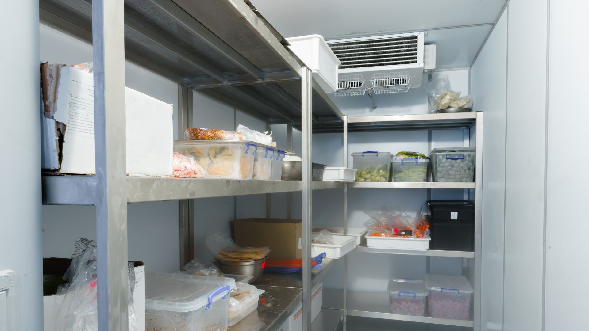 A stainless steel refrigerator filled with lots of food and containers.