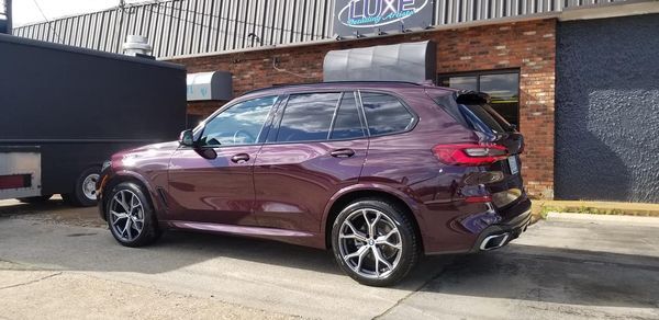 Burgundy SUV parked outside a building with 
