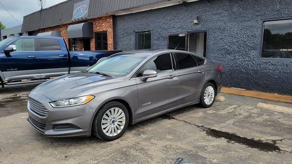 Gray Ford Fusion parked outside a building with a blue truck partially visible on the left.