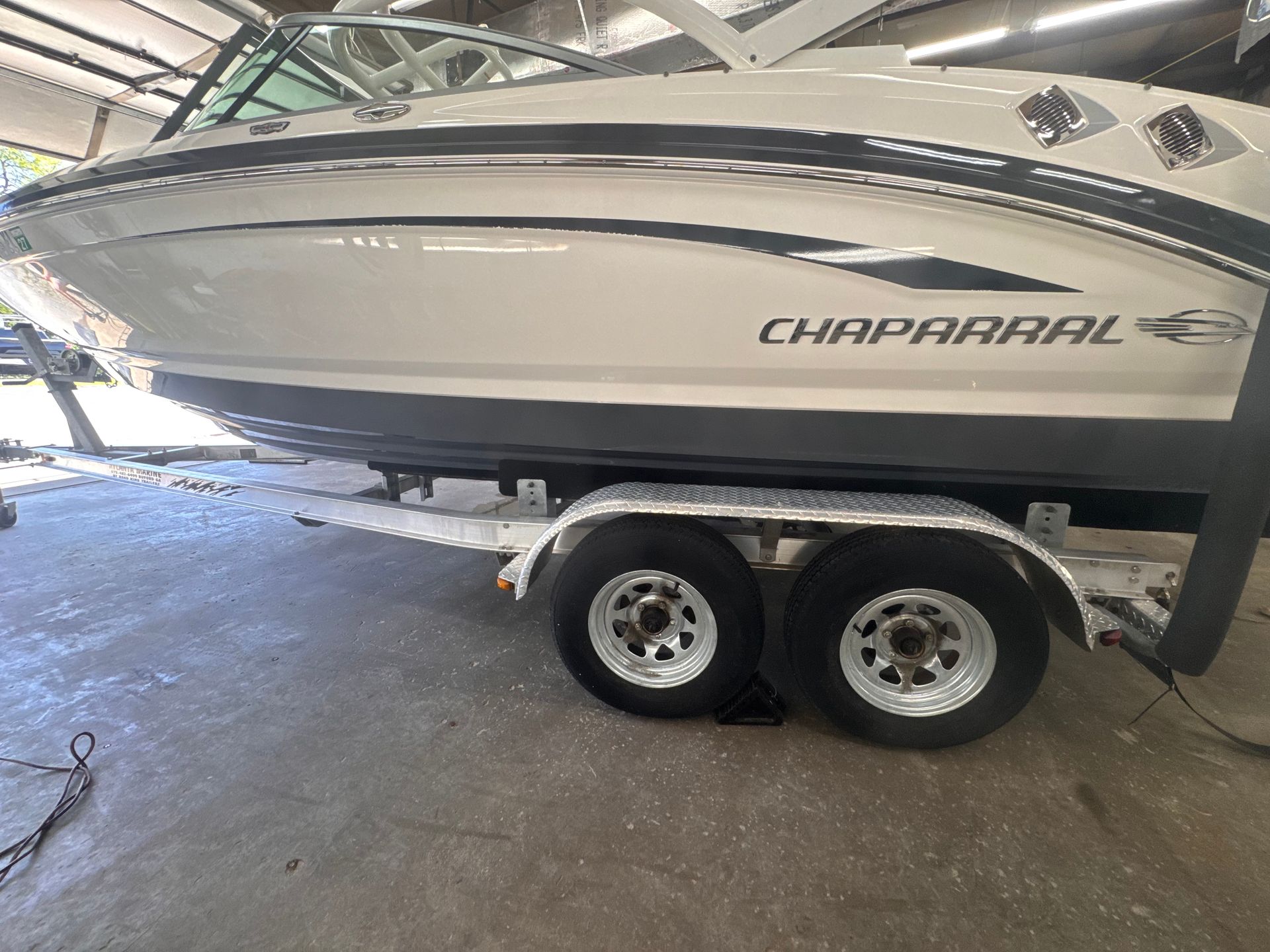 White Chaparral boat on a trailer, indoors. Gray and black accents.