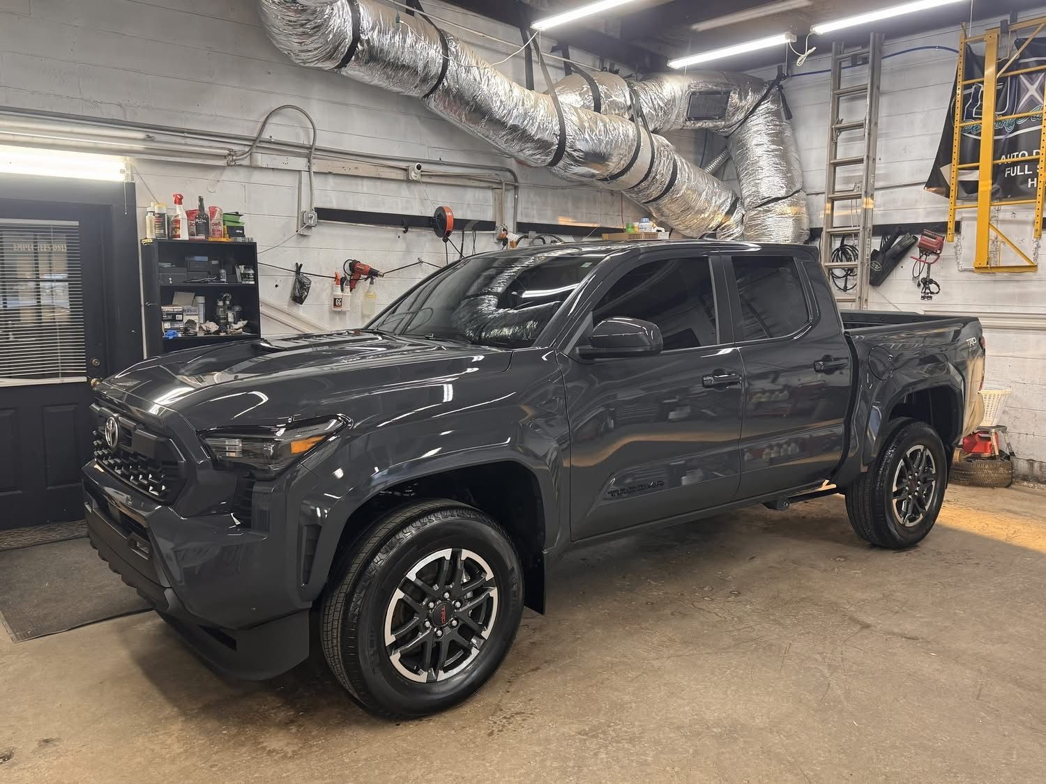 Dark gray Toyota pickup truck parked inside a garage.