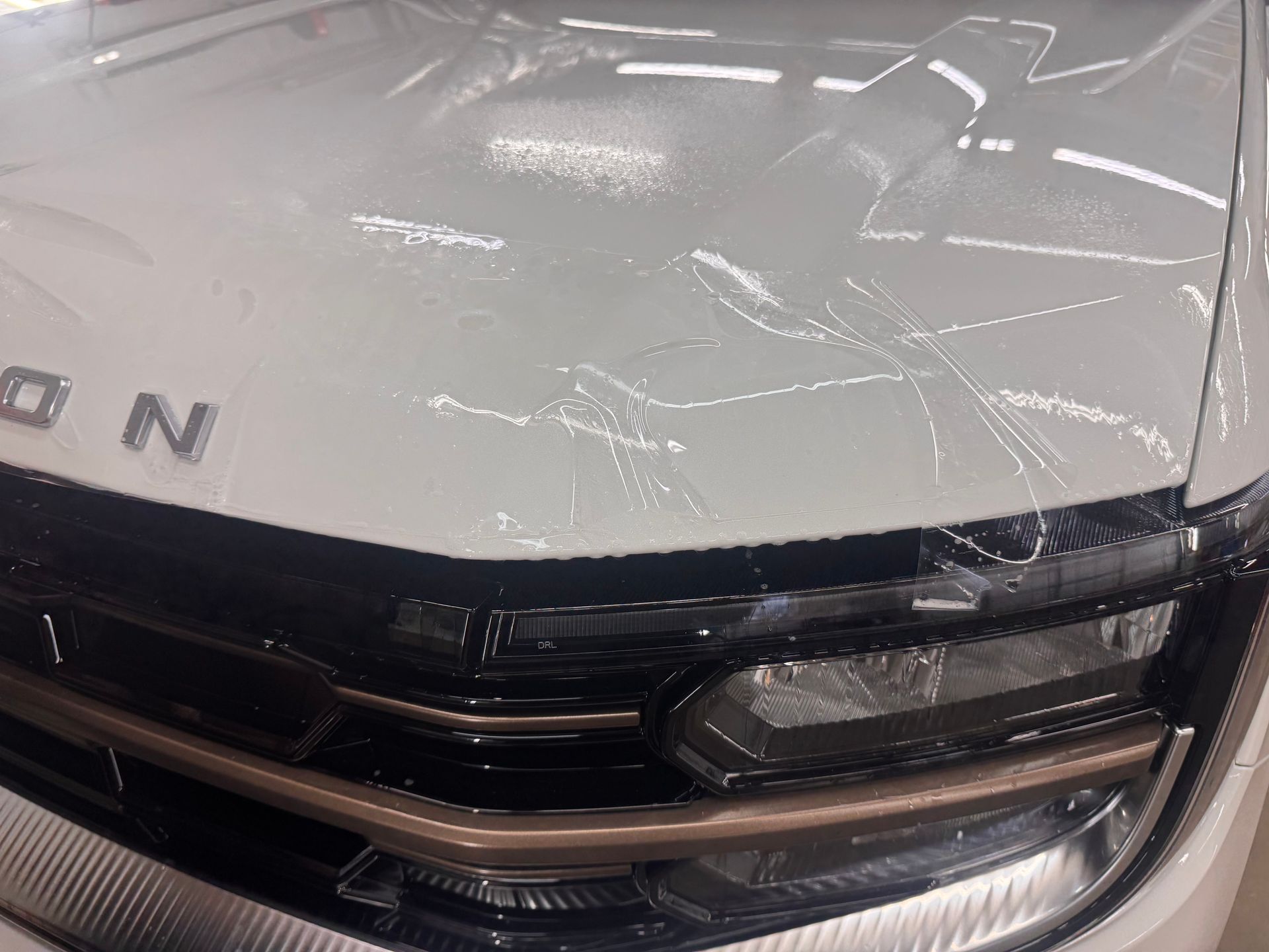 White car hood with clear protective film.