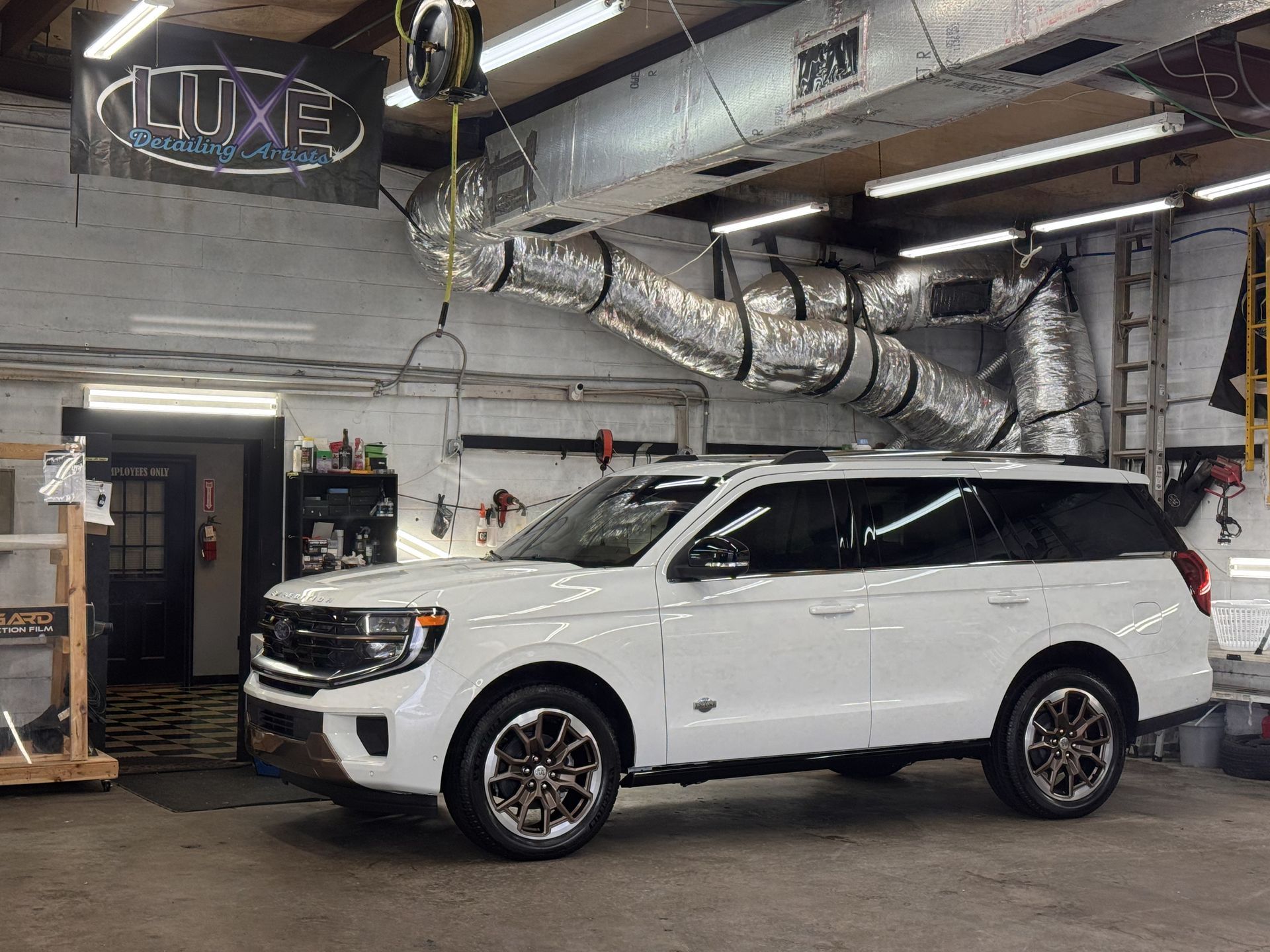 White Ford Expedition SUV inside a garage. 