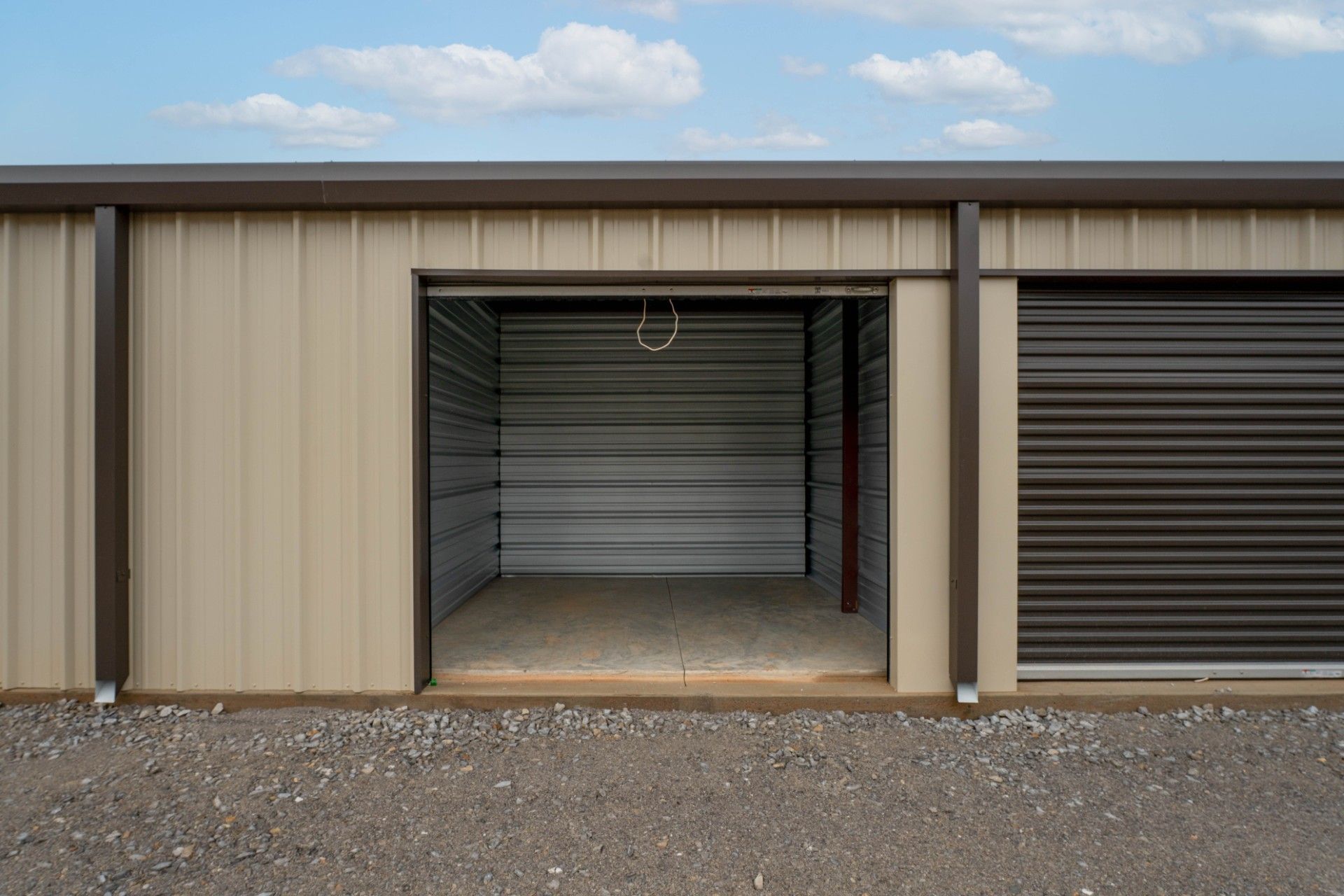 A long hallway with green doors in a storage facility.