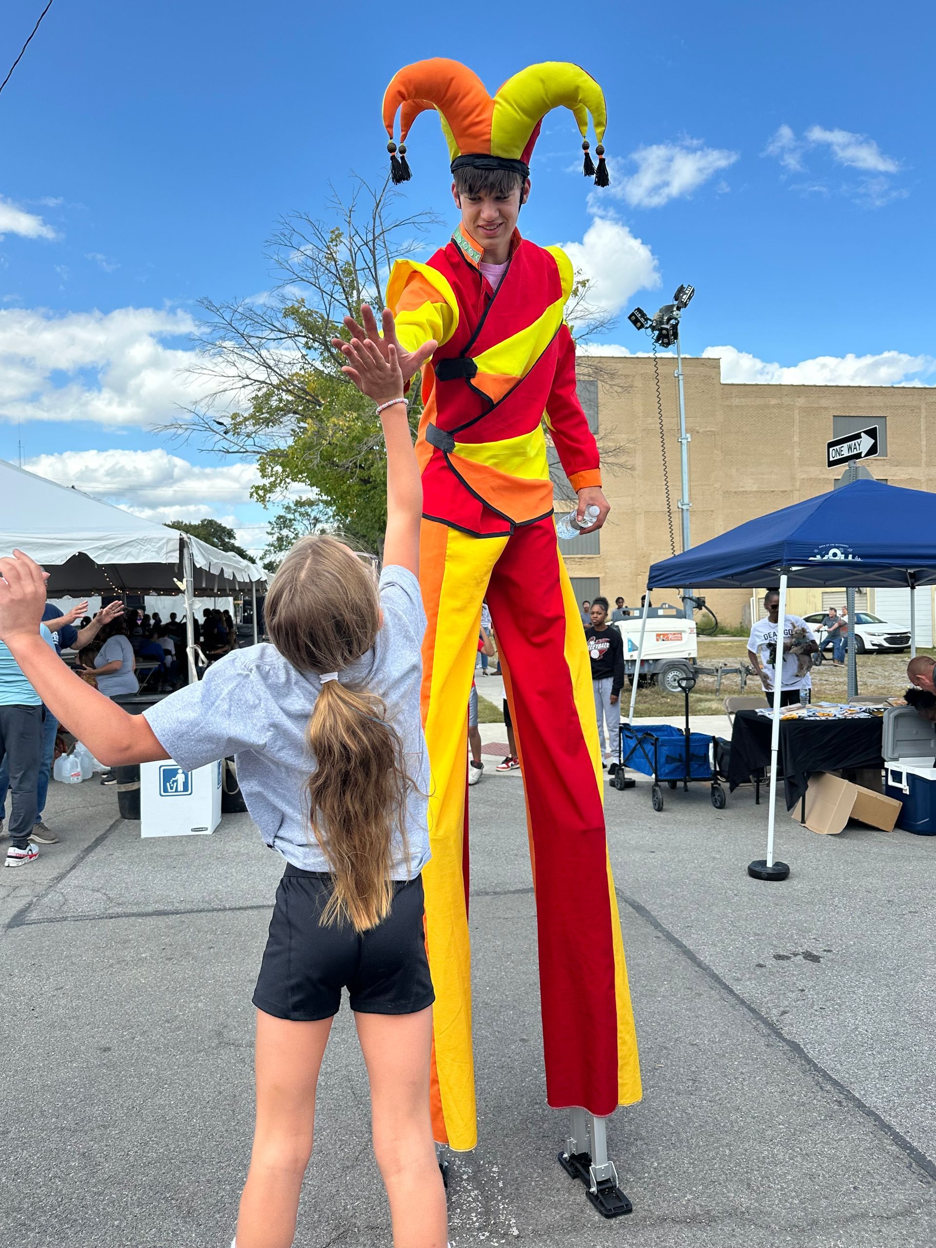 Three people taking a selfie at an outdoor event with stage lights; they are smiling.