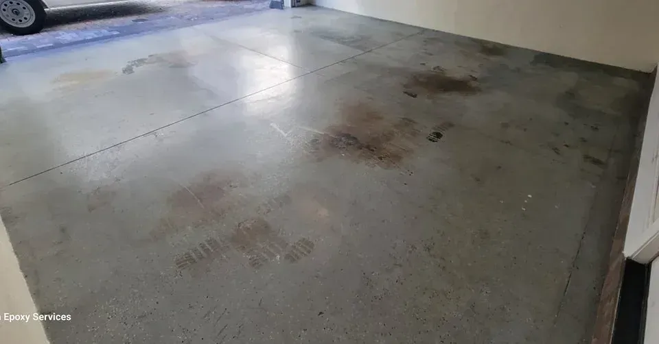 Concrete garage floor with dark stains.