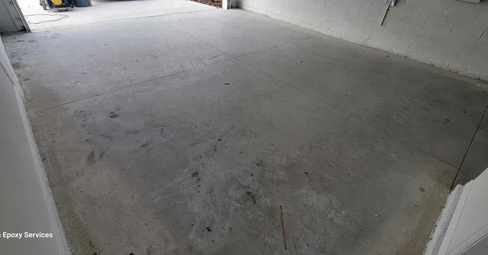 Empty concrete floor in a room, with white walls visible on the sides.