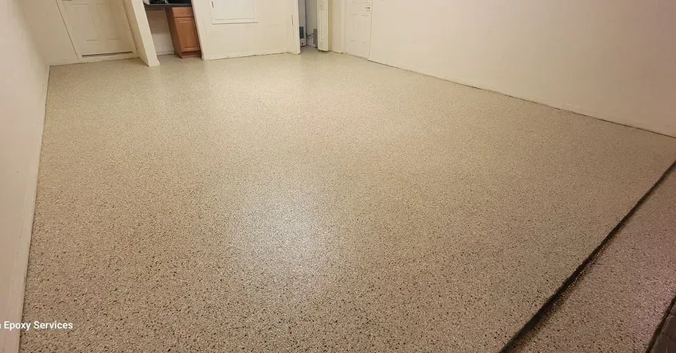A room with a polished, speckled concrete floor and white walls.