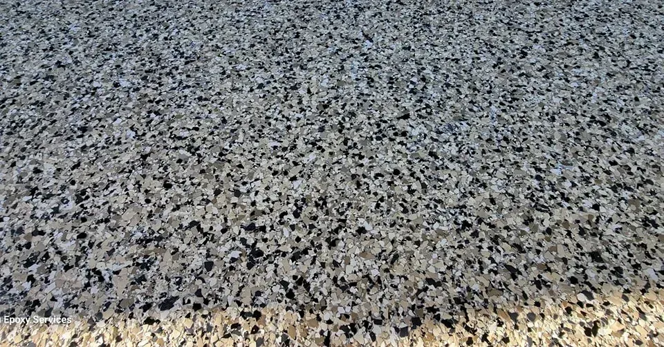 Gray and black speckled surface, possibly flooring or pavement.