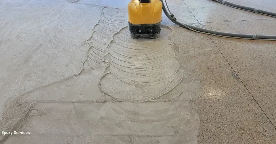 Yellow floor grinder smoothing a concrete floor.