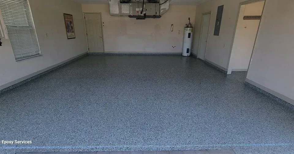 Empty garage with gray speckled epoxy floor and white walls.