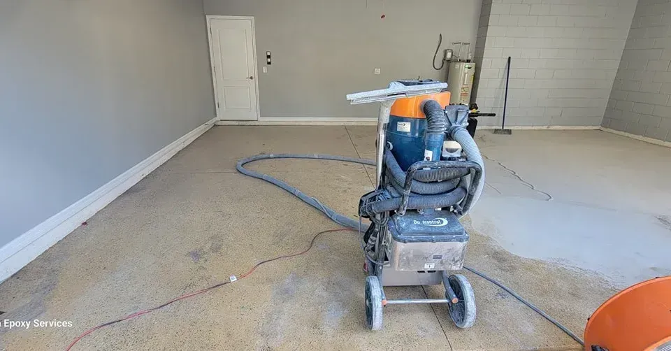 Floor grinder in a gray-walled garage, grinding the floor.
