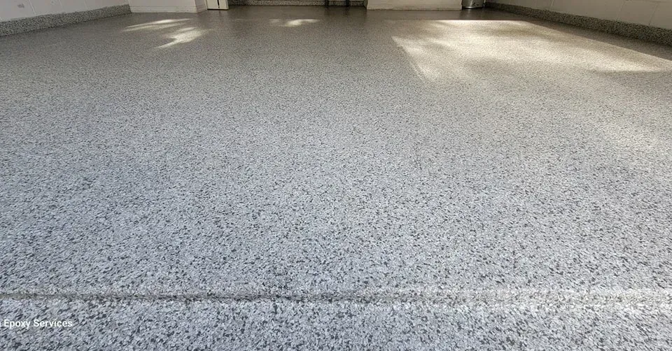 Grey speckled epoxy flooring in a spacious room with sunlight.