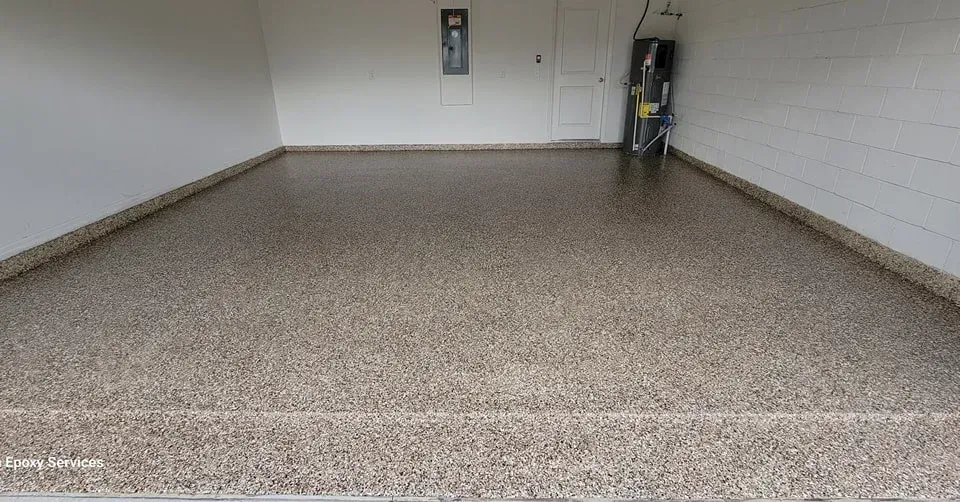 A garage interior with a speckled concrete floor and white walls.