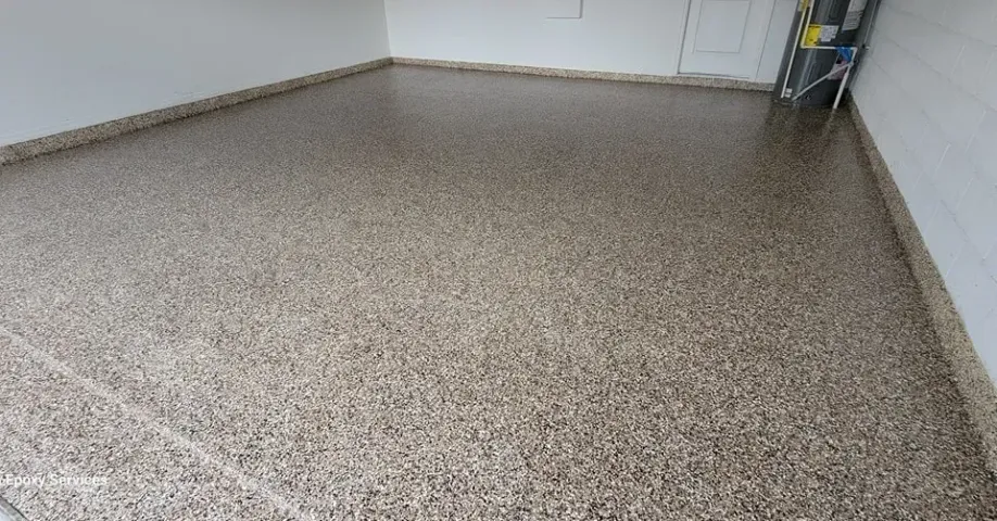 Garage floor with a speckled epoxy coating, reflecting the room's light.