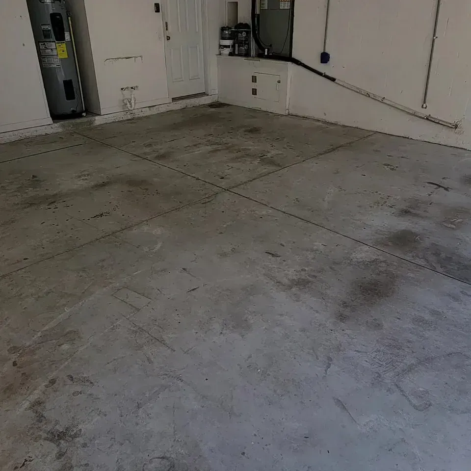 Concrete garage floor with black lines, appliances in the background.