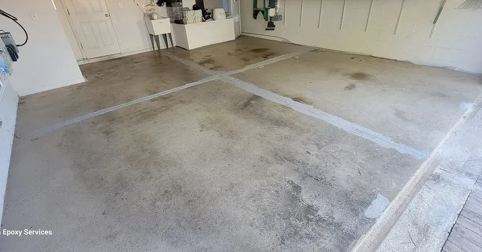 Garage with concrete floor, white lines, and a sink in the background.