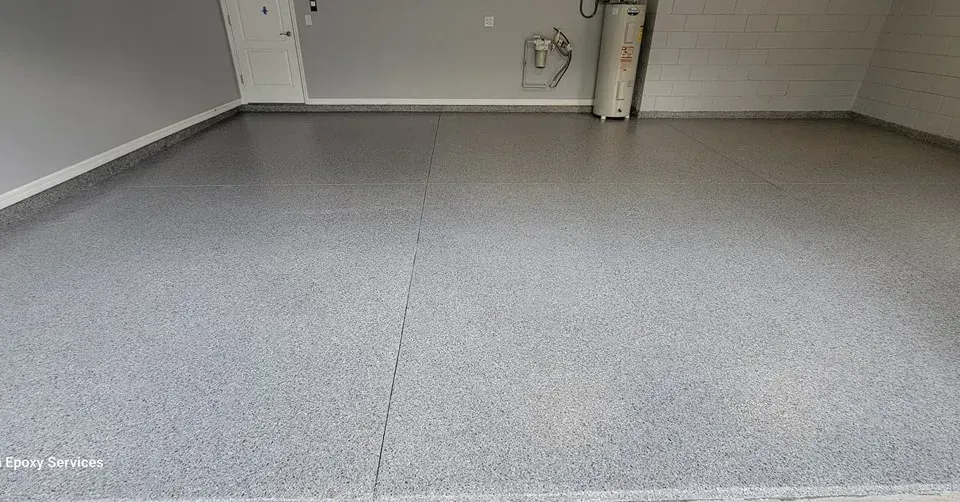 A clean garage with a speckled gray epoxy floor. Walls are gray, a water heater is visible.